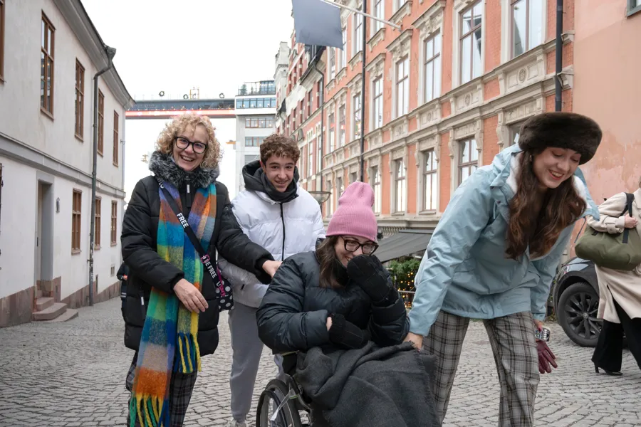 Unge mennesker sammen ute. en sitter i rullestol.