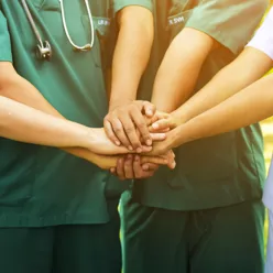 Bilde av flere hender sammen, helsepersonell - viser samarbeid