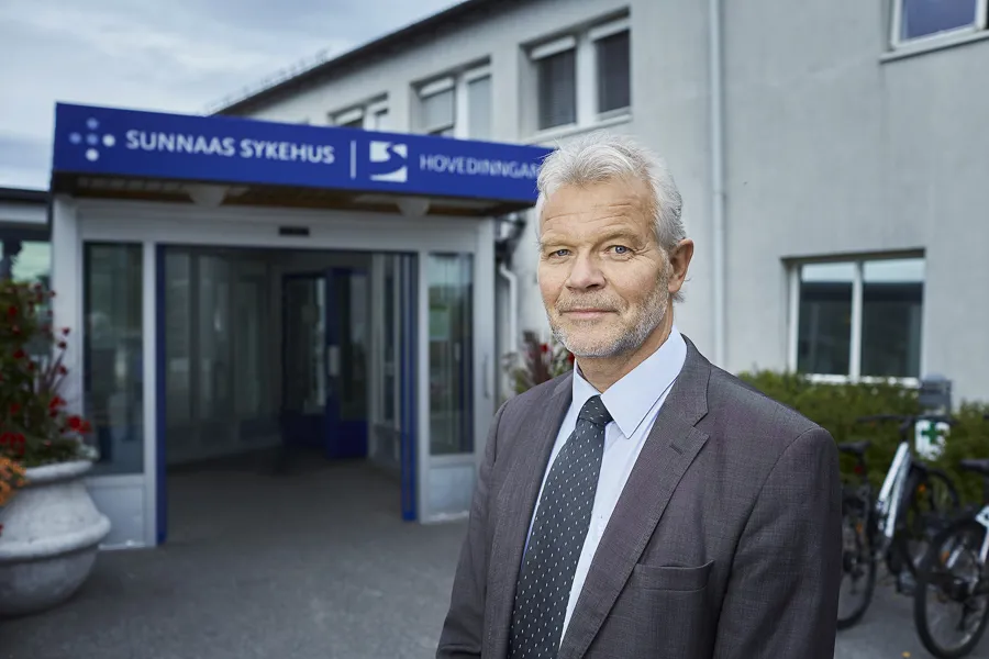 En mann i dress utenfor en bygning