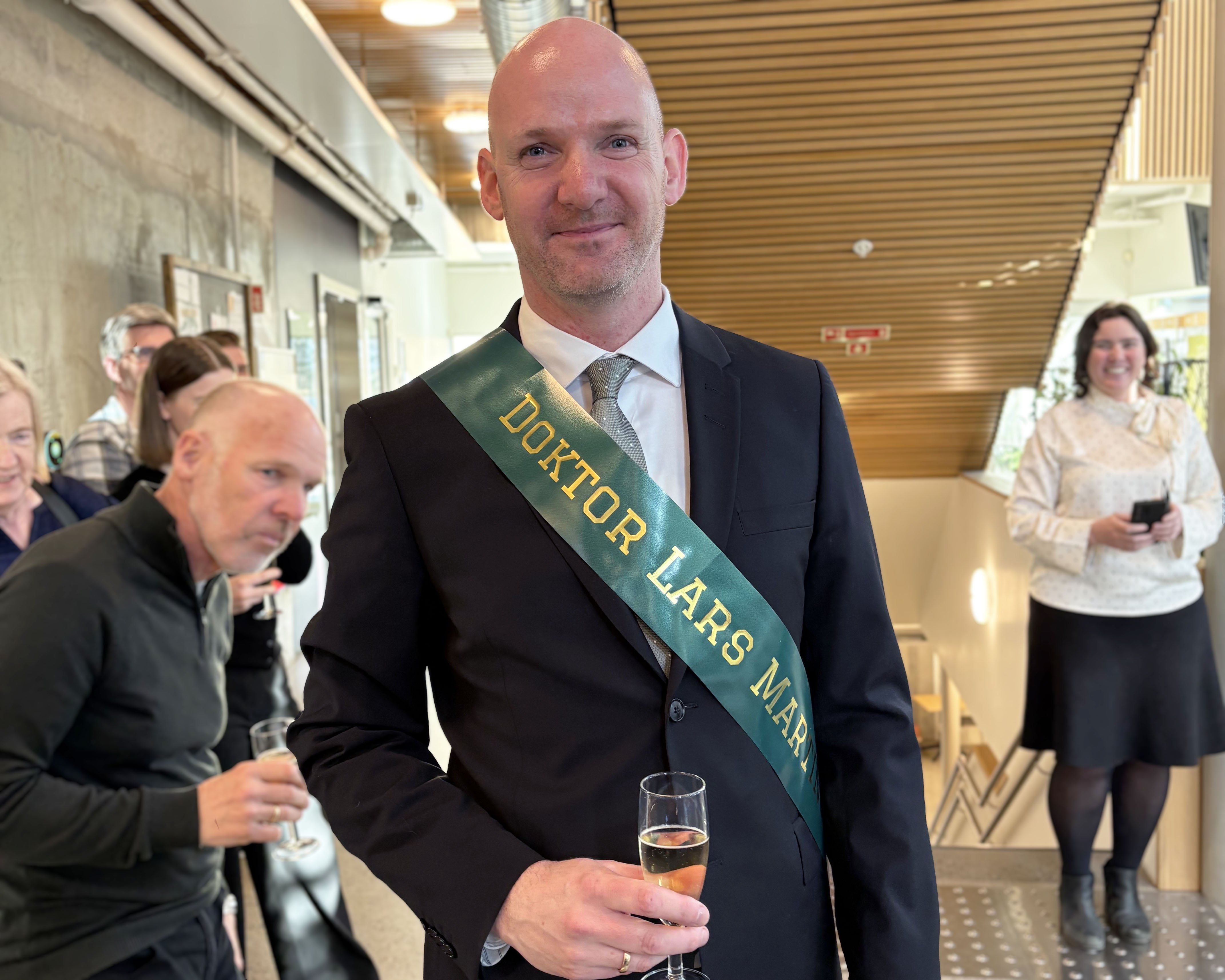 Bilde av Lars Martinsen etter hans disputas. Han har på et ordensbånd hvor det står "Doktor Lars Martinsen"