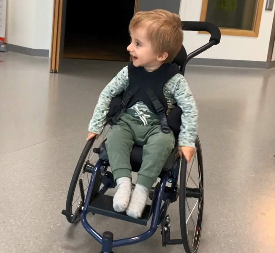 En baby som sitter i rullestol