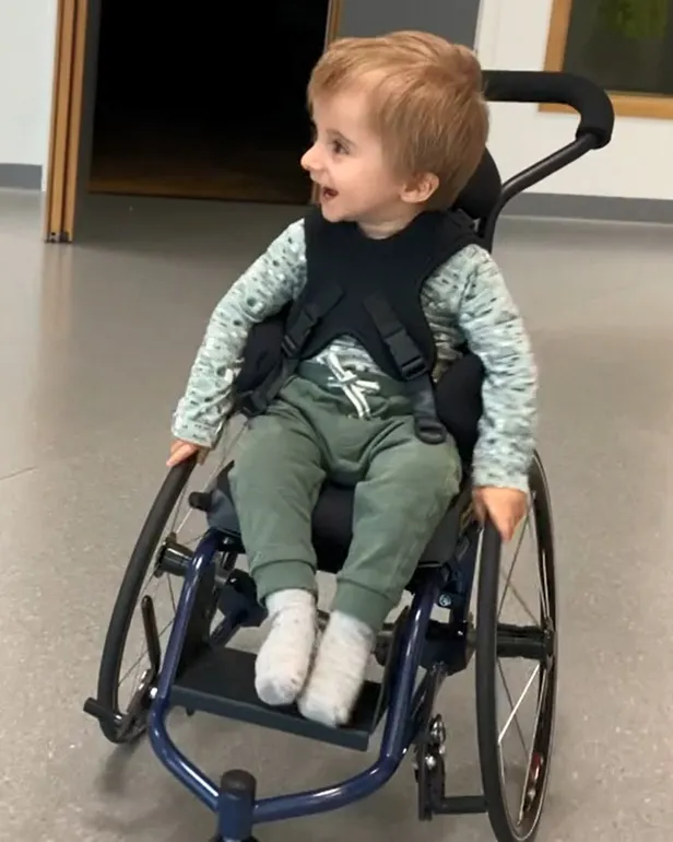 En baby som sitter i rullestol