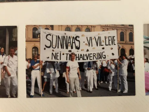 En gruppe mennesker som holder et skilt