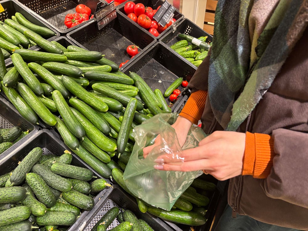 A person holding a bag of vegetables