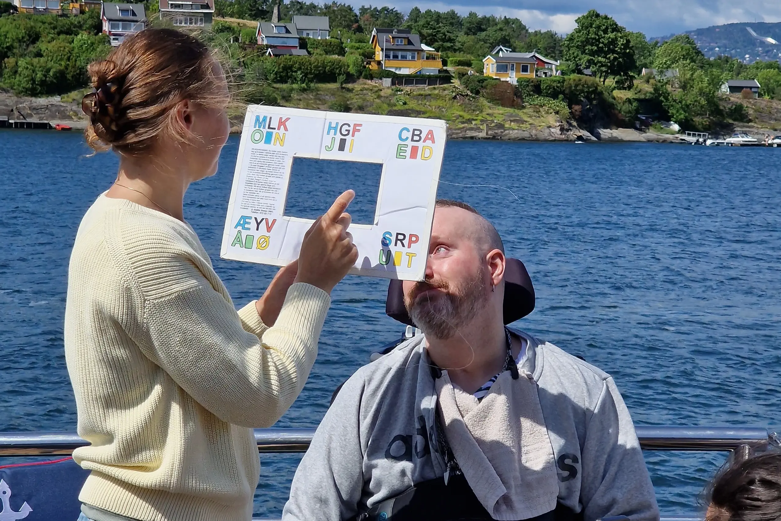 En mann som leser en bok for en kvinne på en båt