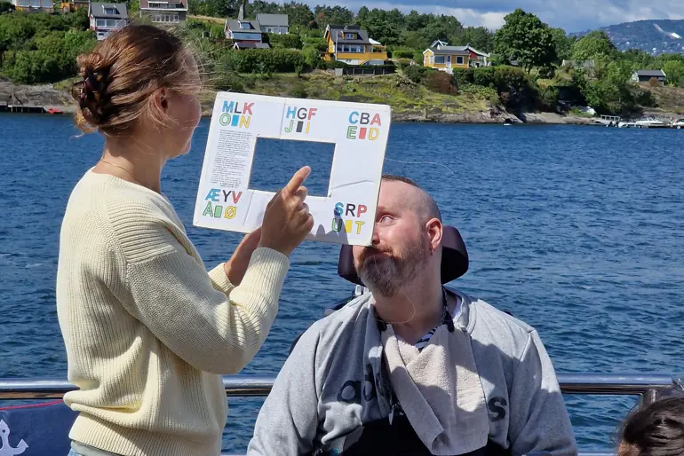 En mann som leser en bok for en kvinne på en båt