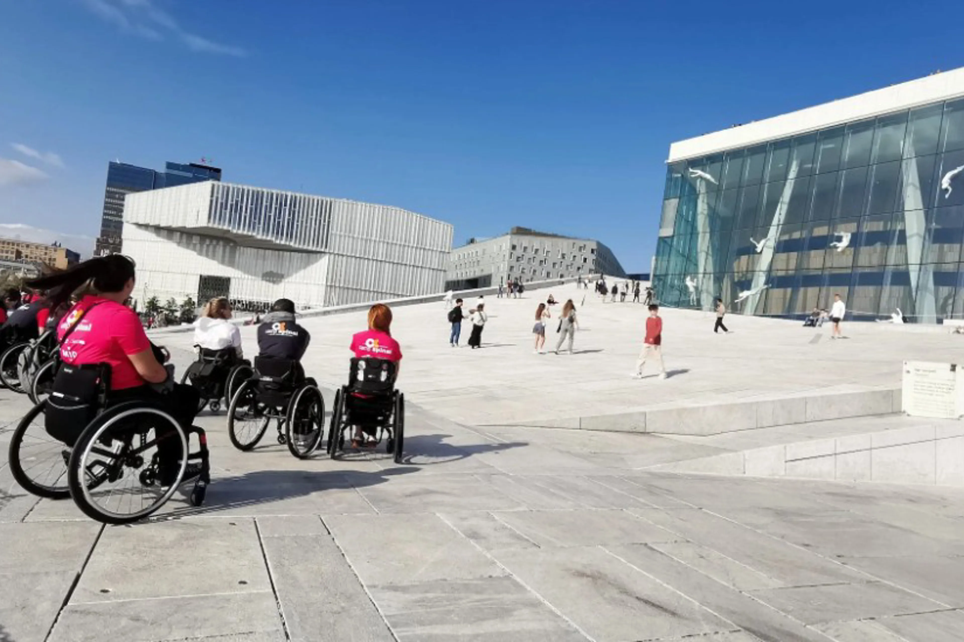 People in wheelchairs in front of a building