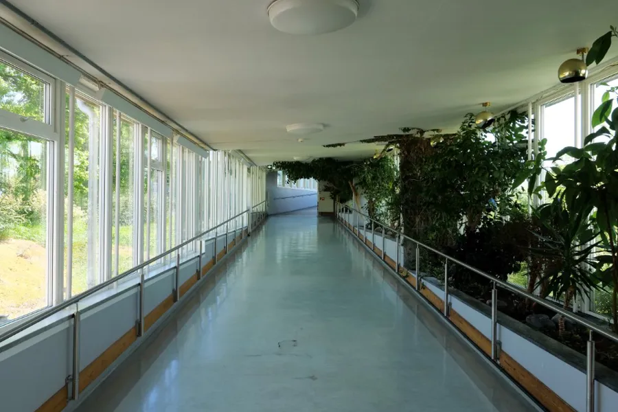 En lang hvit gang med vinduer