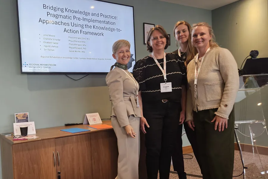 En gruppe kvinner som står foran en stor skjerm