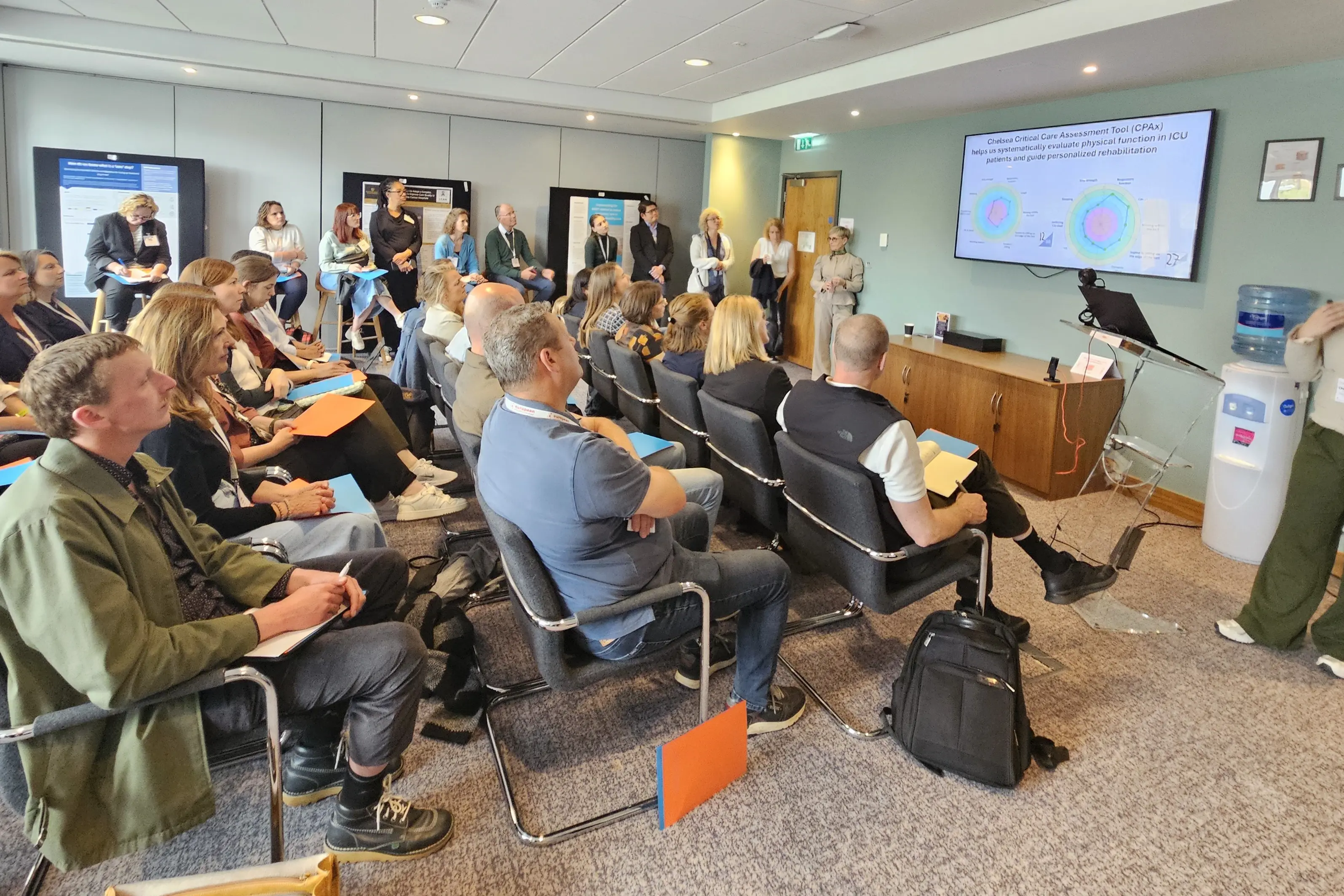 En person som snakker med en gruppe mennesker i et rom