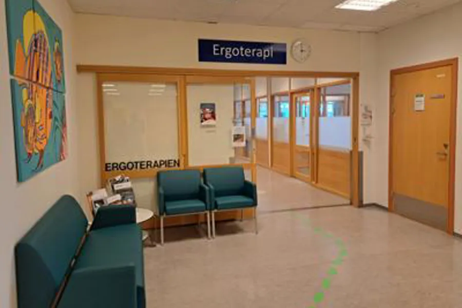 Et rom med blå stoler og et skilt på veggen