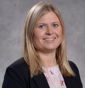 En kvinne som smiler til kameraet