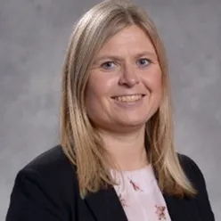 En kvinne som smiler til kameraet