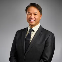 A man in a suit smiling