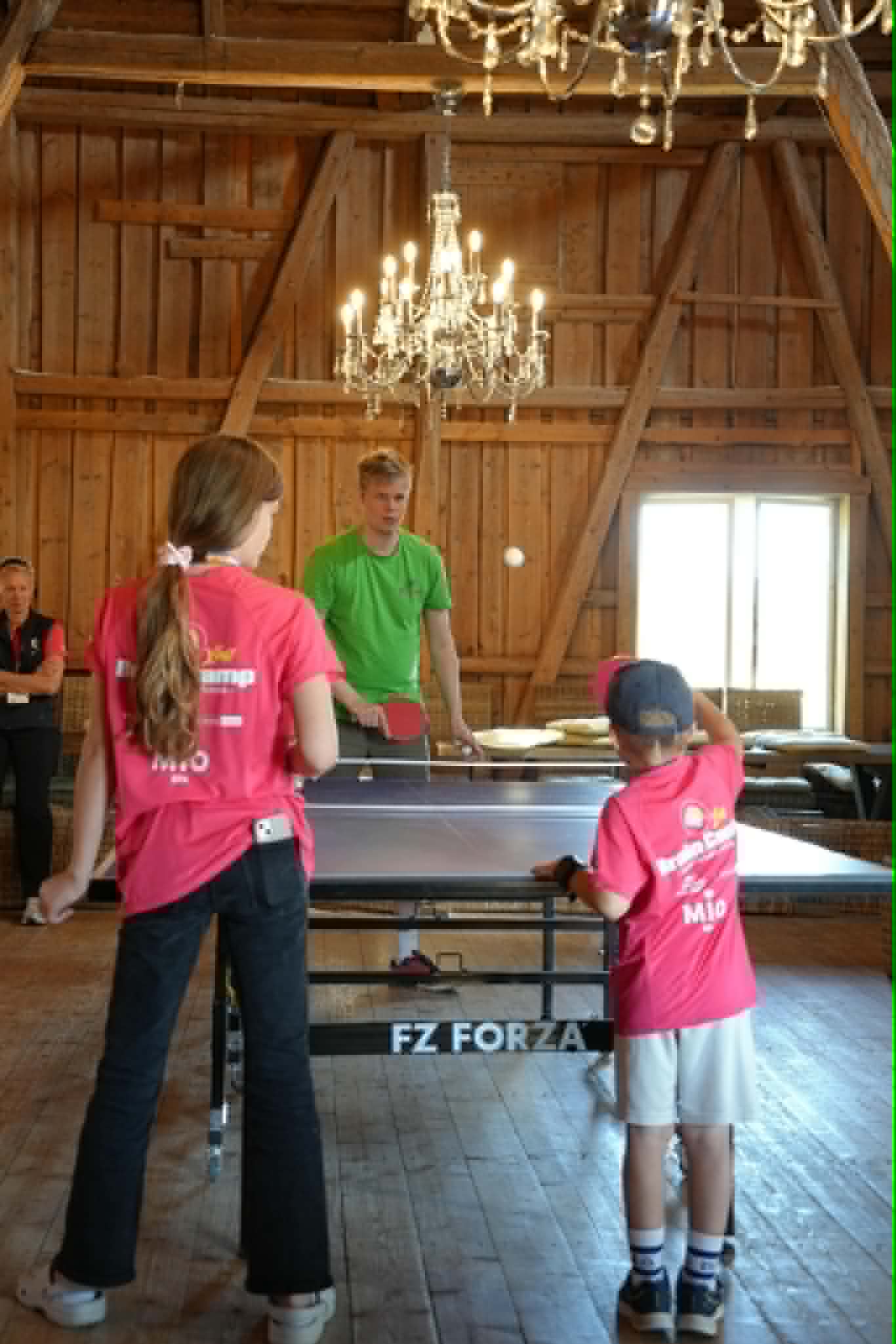Tre barn som spiller bordtennis