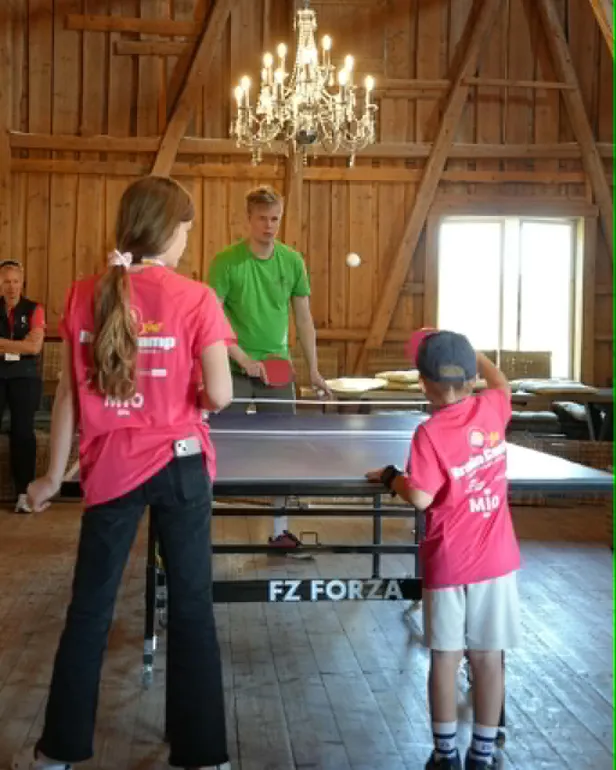 Tre barn som spiller bordtennis