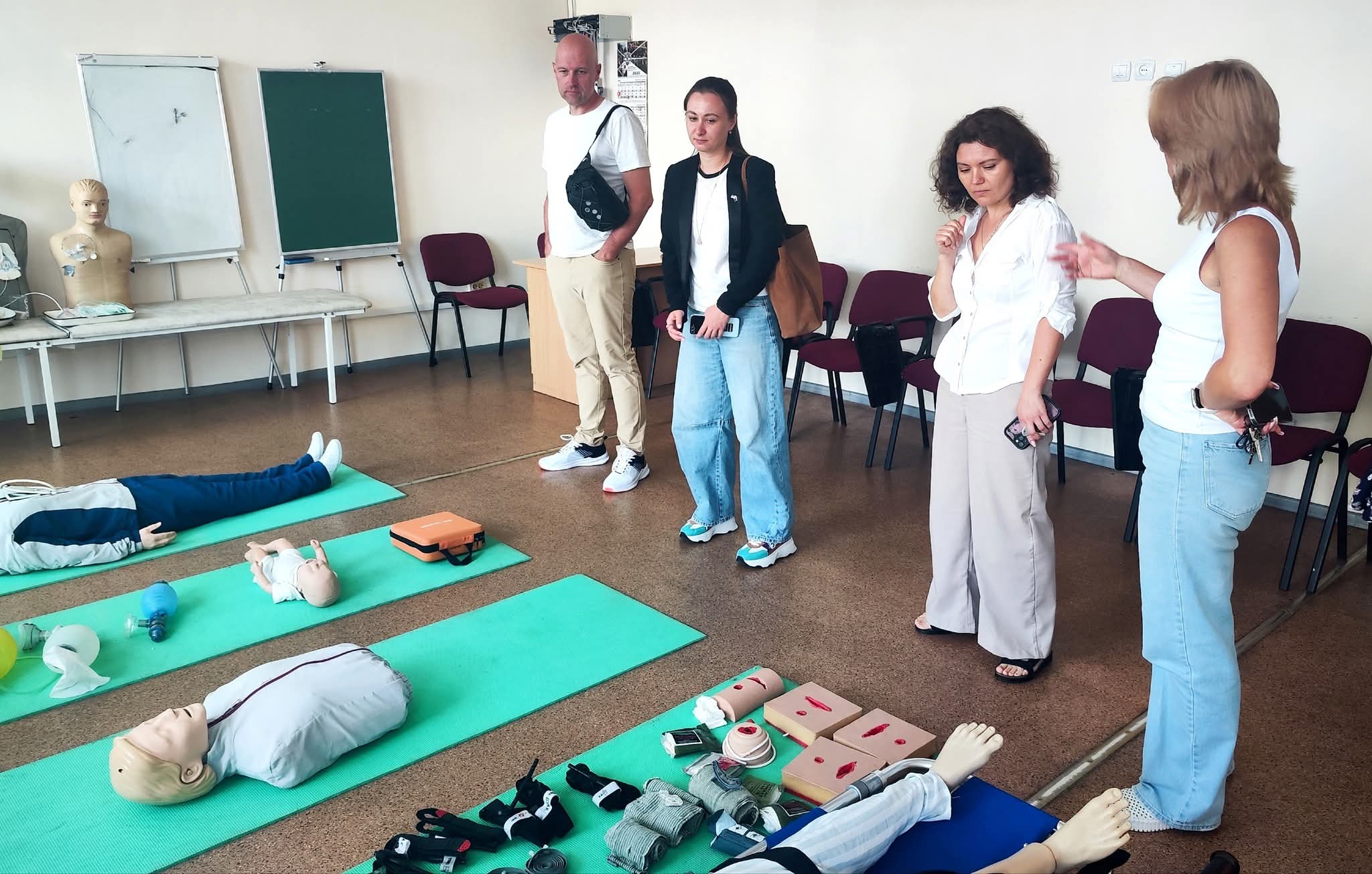 En gruppe mennesker som står rundt en person som ligger på bakken