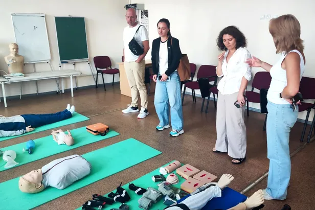 En gruppe mennesker som står rundt en person som ligger på bakken