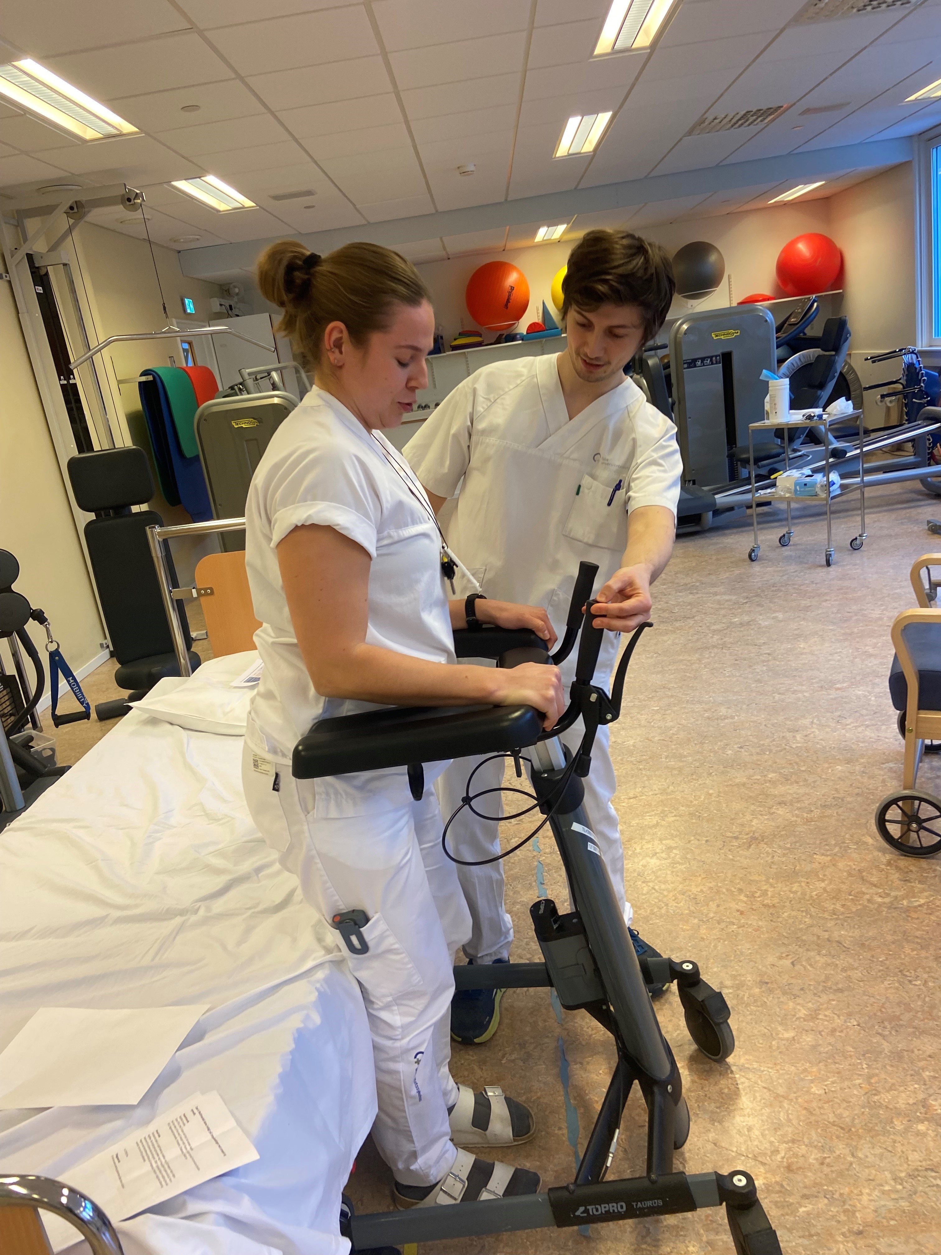 Et par kvinner i hvite laboratoriefrakker som jobber på en maskin