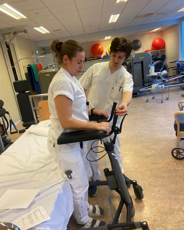 Et par kvinner i hvite laboratoriefrakker som jobber på en maskin