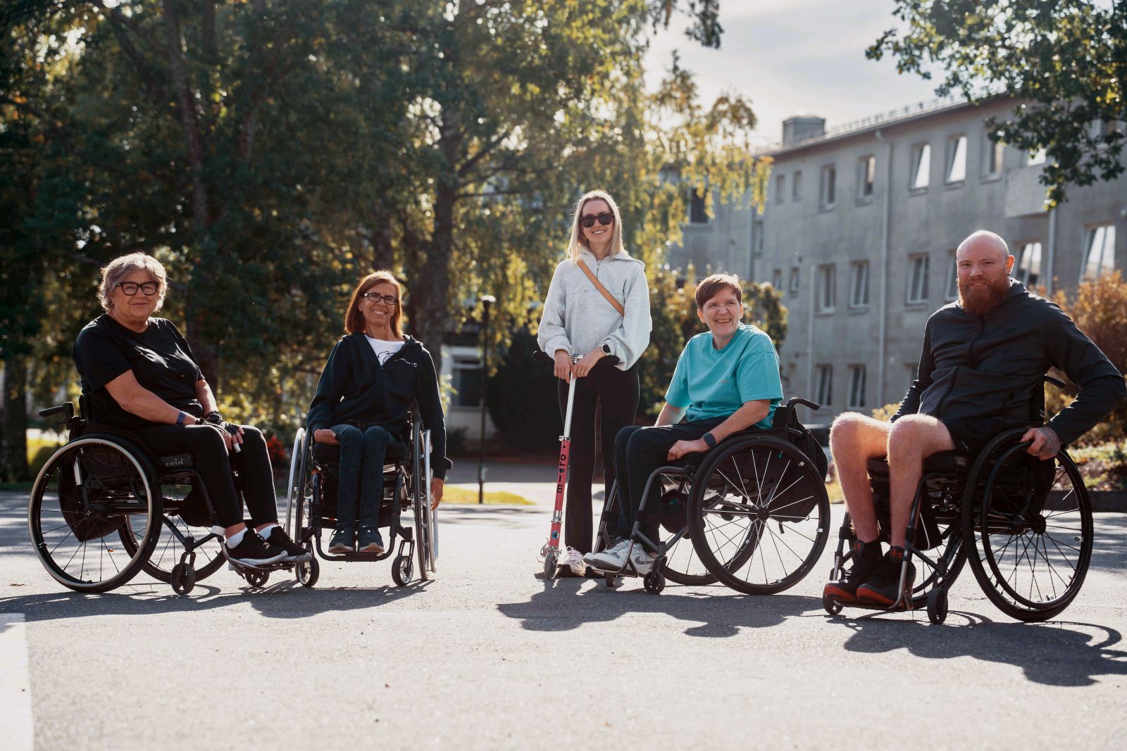 En gruppe mennesker som sitter i rullestol, en person står med krykker.