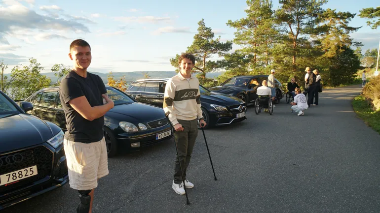 To gutter står foran noen biler