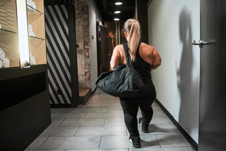 Kvinne med akondroplasi går bortover gang