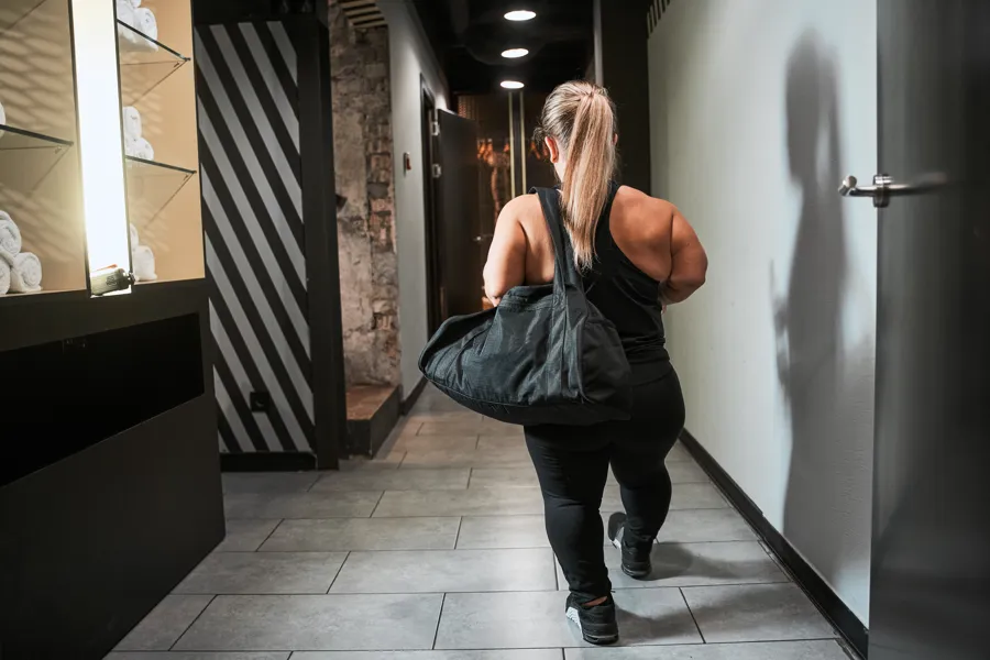 Kvinne med akondroplasi går bortover gang