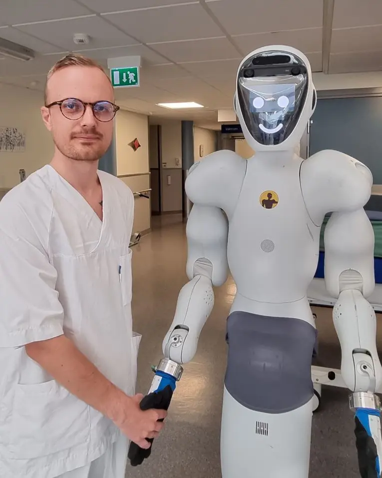 helsefagarbeider hilser på robot