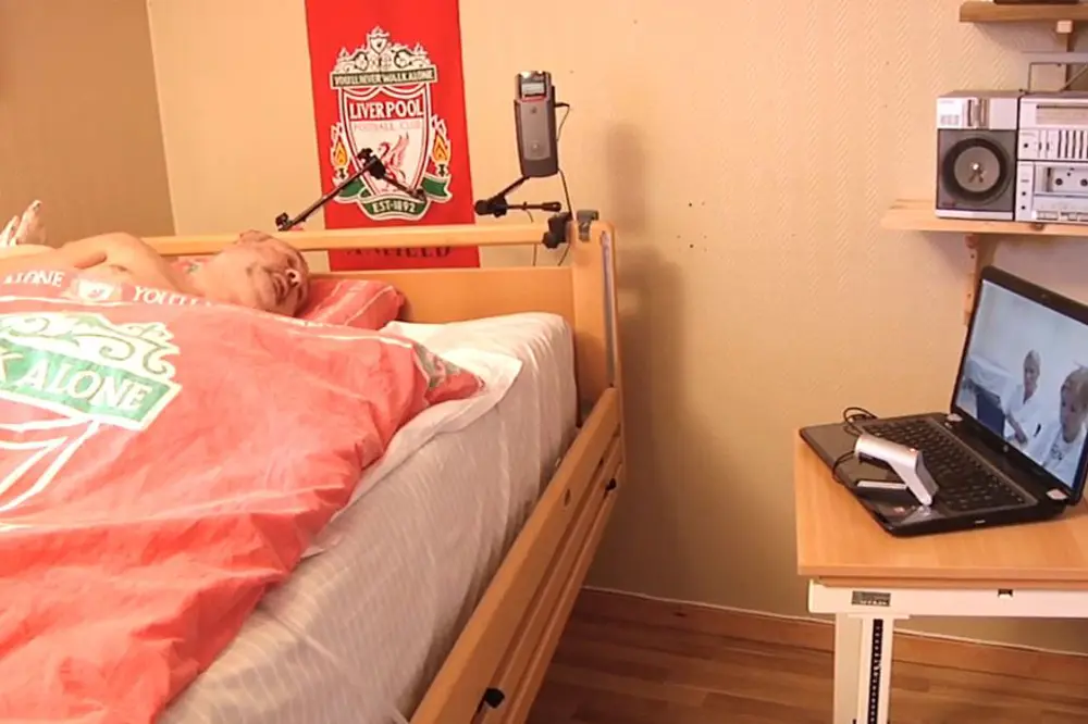 Pasient i seng kikker på PC-skjerm