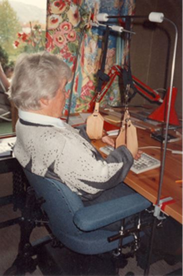 Bilde av dame som skriver på datamaskin med armene støttet i slynger