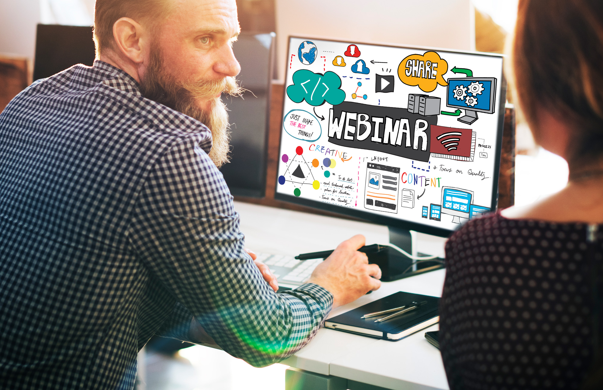 En mann som viser en kvinne noe på datamaskinen