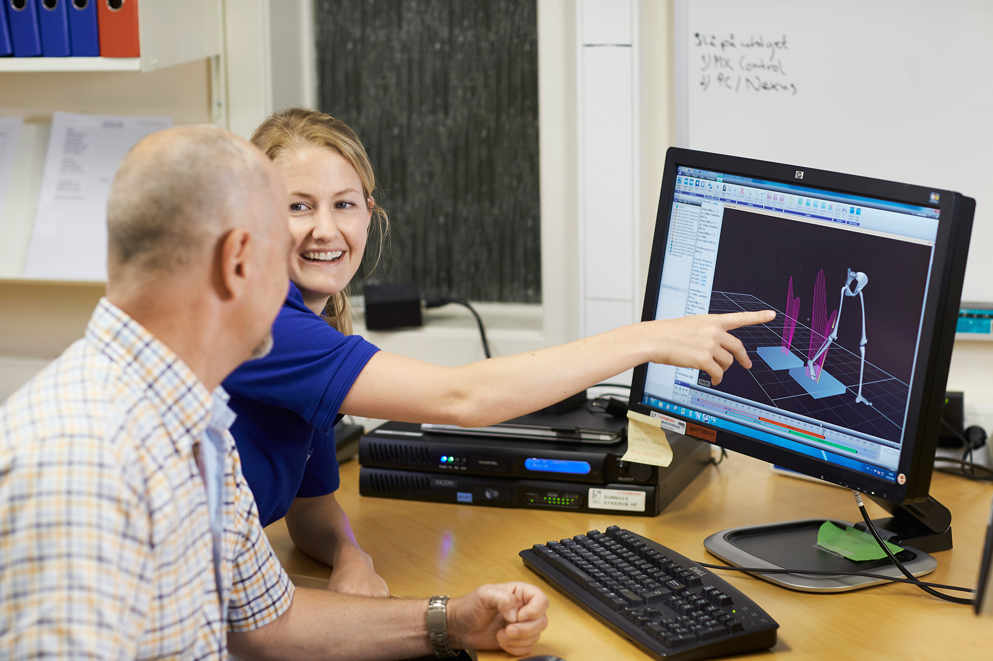 En mann som viser en gutt noe på datamaskinen