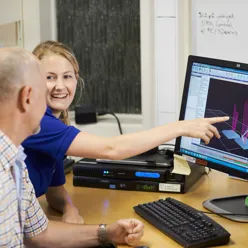 A man showing a boy something on the computer
