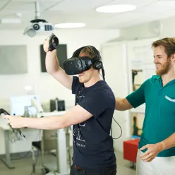 A person wearing a virtual reality headset and a person wearing a virtual reality headset