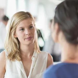 to kvinner snakker med hverandre