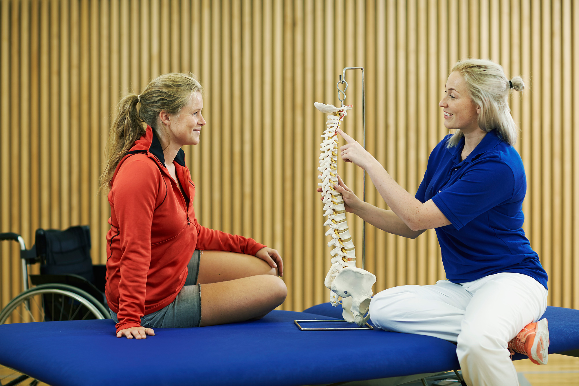 A person holding a sword and a person sitting on a blue table