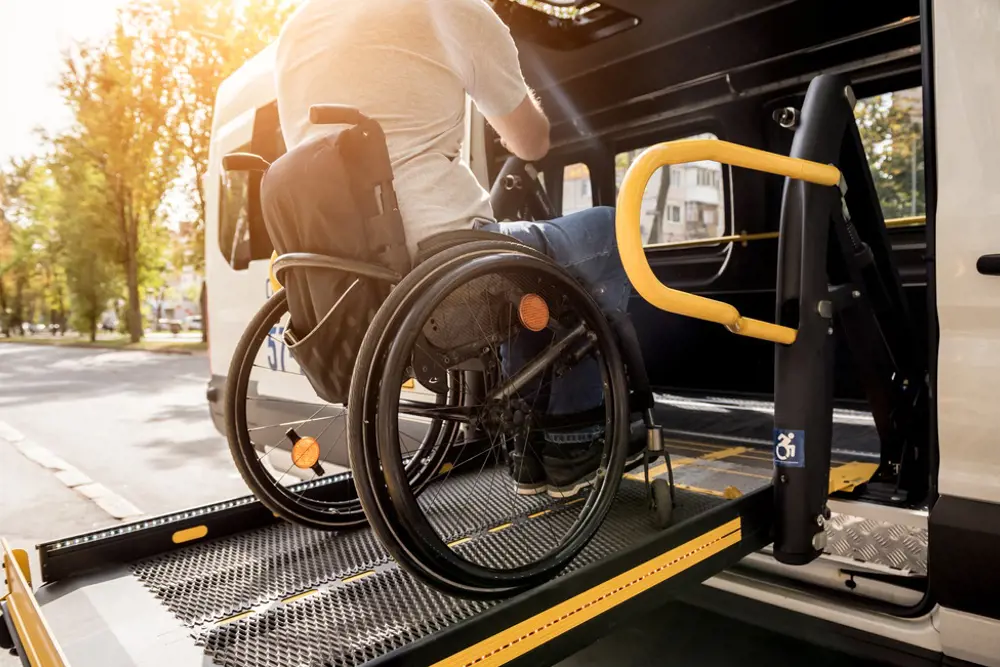 Bilde av rullestolbruker som bruker rampe for å komme inn i bilen