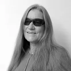 En kvinne med langt hår med solbriller