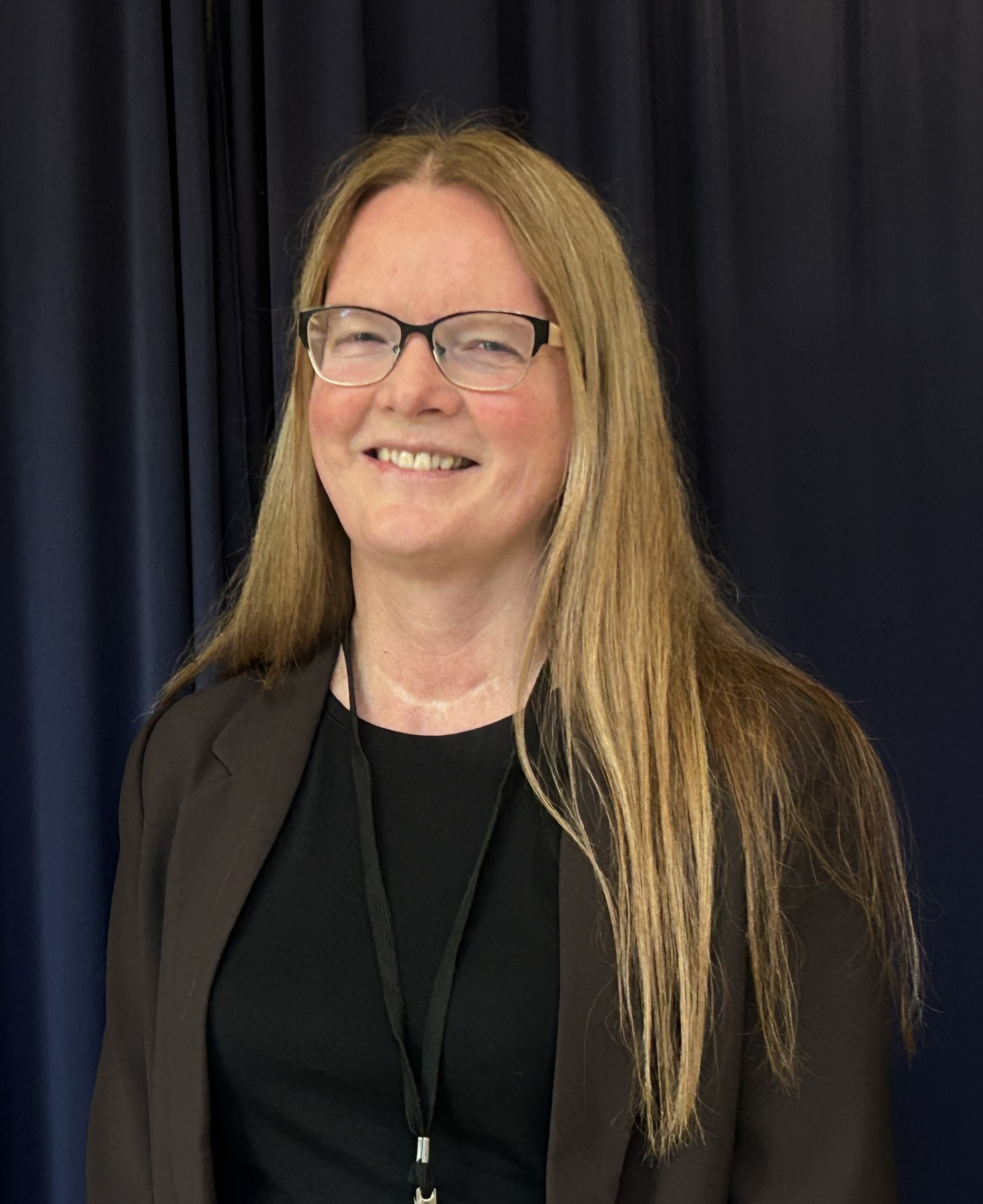 A person with long hair smiling