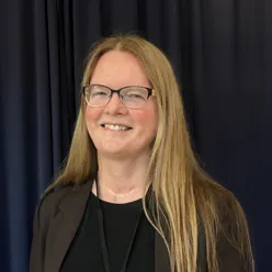 A person with long hair smiling