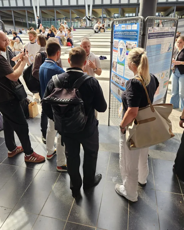 En gruppe mennesker i et stort rom med et skilt