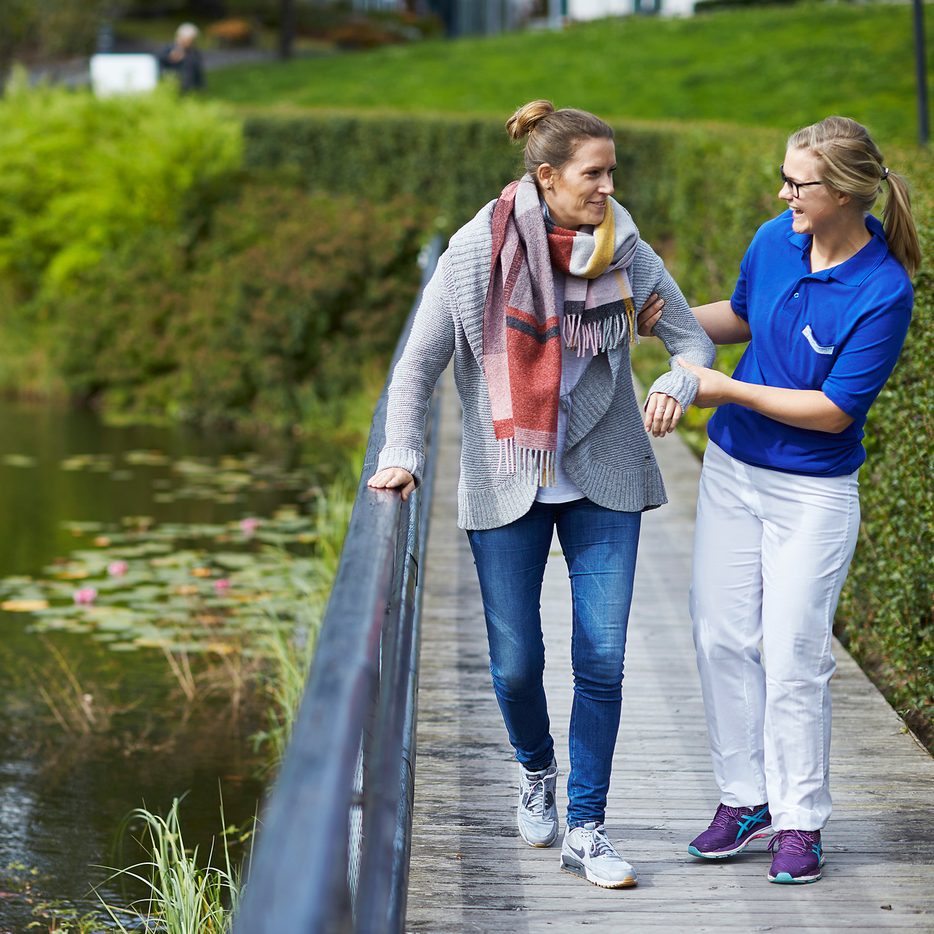 Fysioterapeut går sammen med pasient over en bro