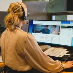 En person som har på seg hodetelefoner og ser på en skjerm