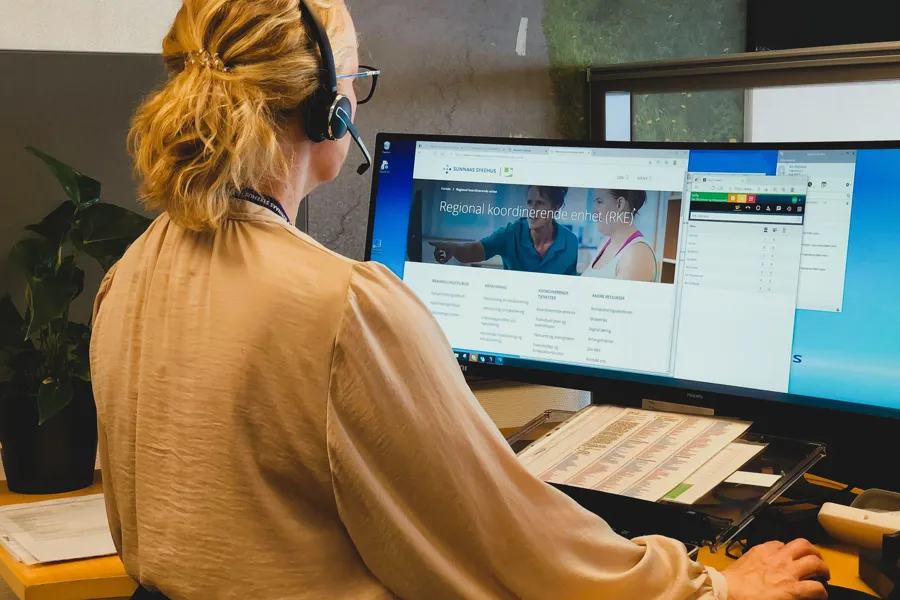 En person som har på seg hodetelefoner og ser på en skjerm