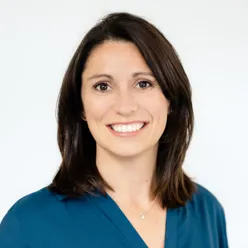 En kvinne som smiler til kameraet