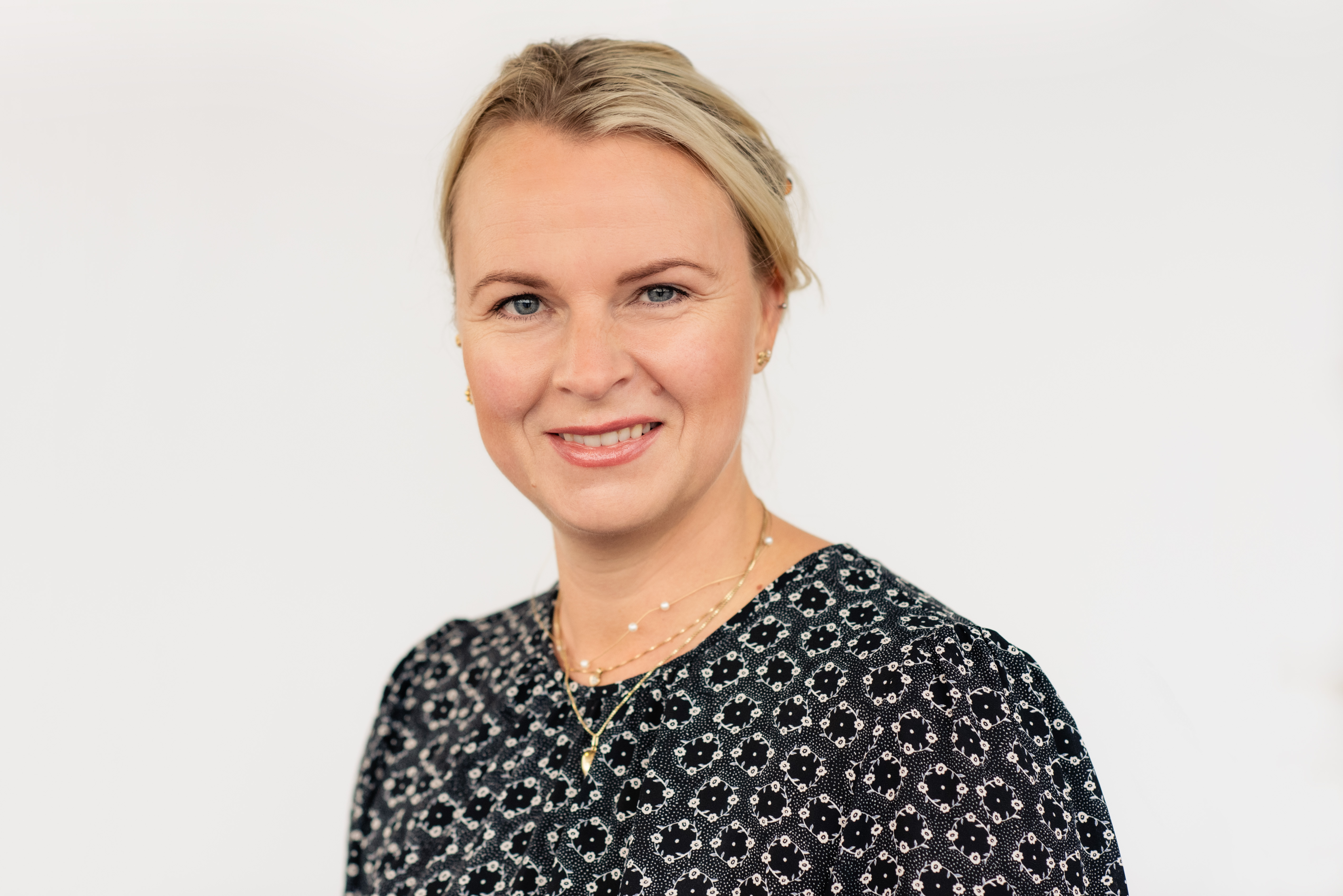 En kvinne som smiler til kameraet