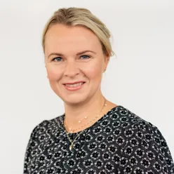 En kvinne som smiler til kameraet