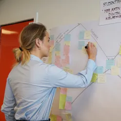 En person som skriver på en tavle