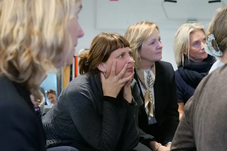 En gruppe kvinner som sitter i et rom